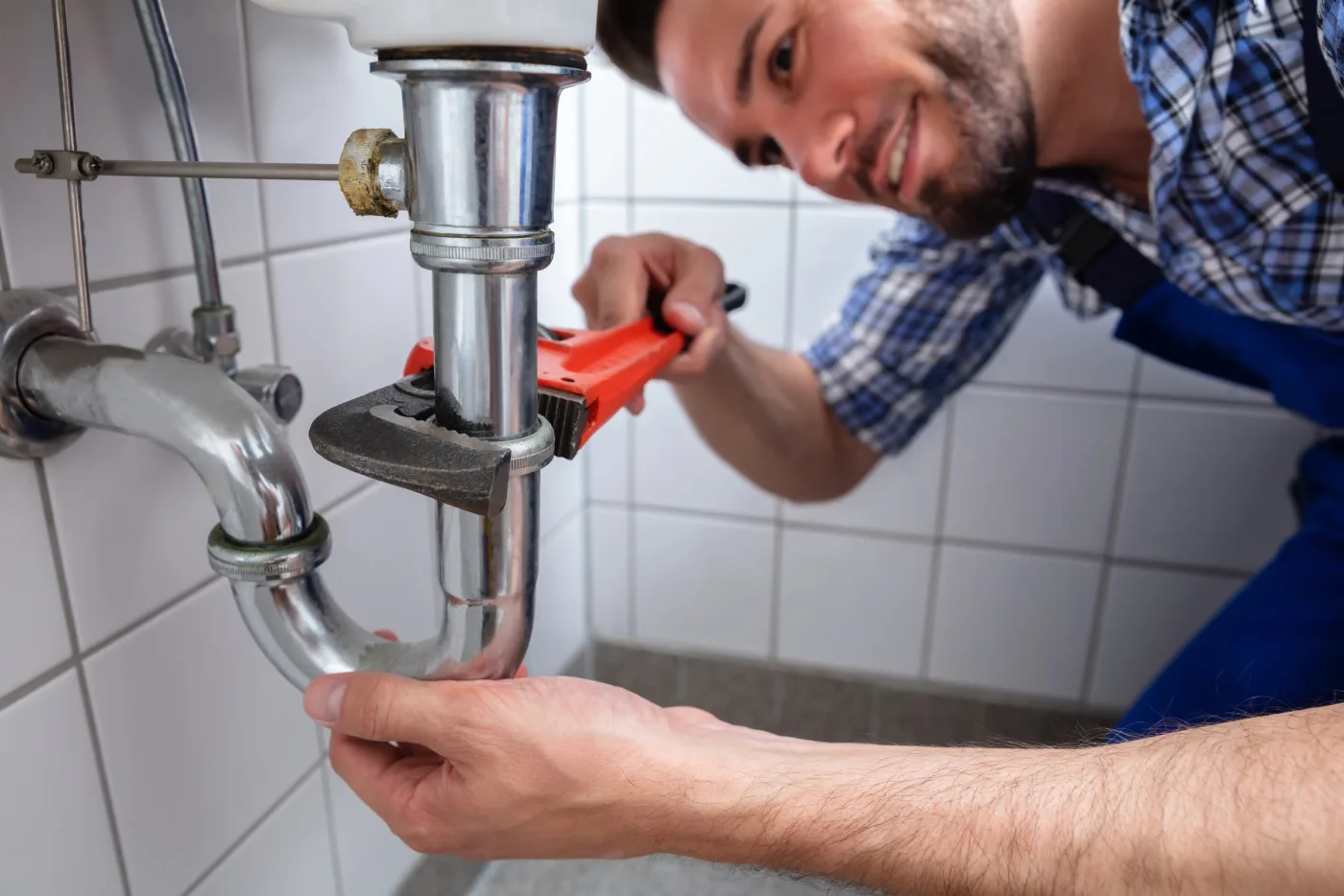 Démontage d'un siphon sous évier lors d'un débouchage à Étampes